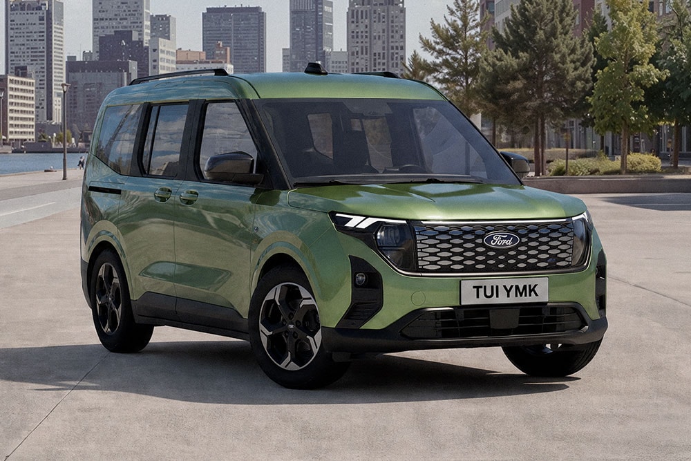 Zielony E-Tourneo Courier zaparkowany na tle miejskiej zabudowy.