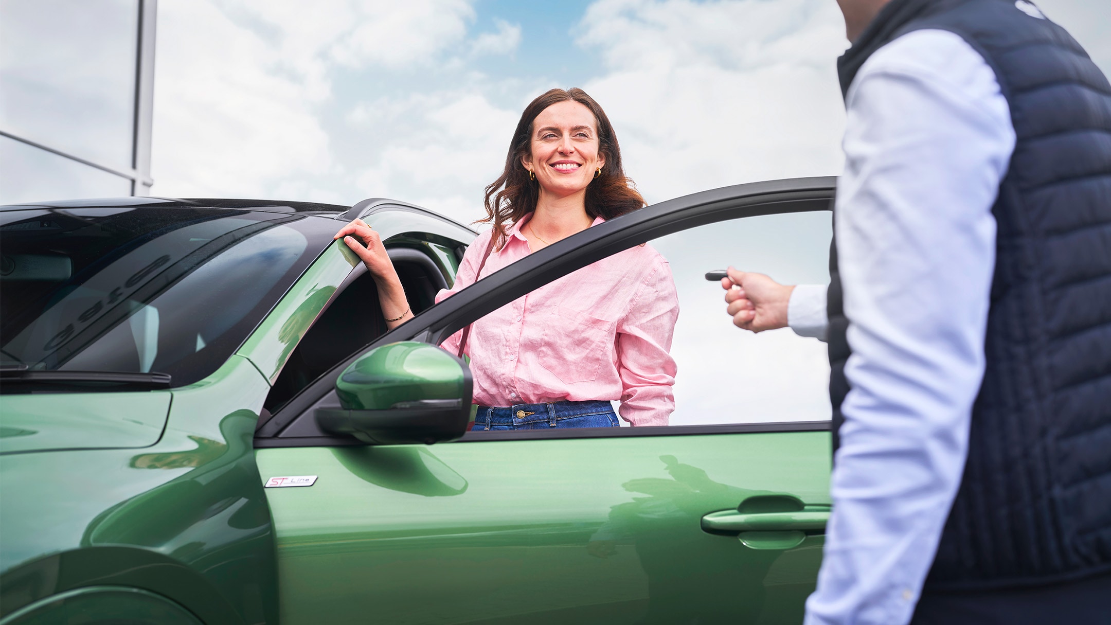 Klientka odbiera kluczyki do zielonego Forda w autoryzowanym serwisie.