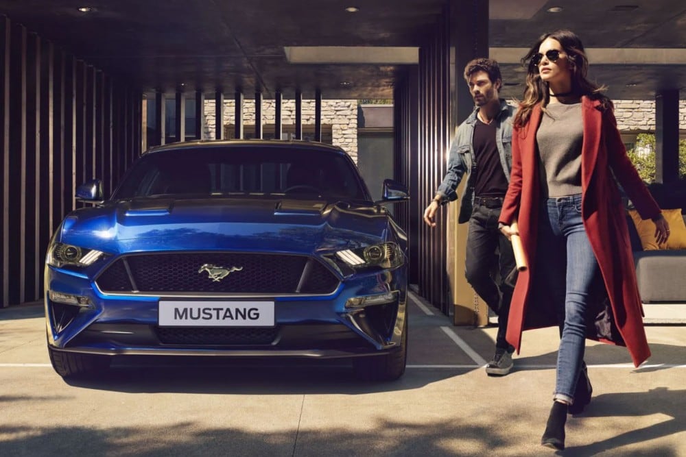 Niebieski Ford Mustang zaparkowany przed domem