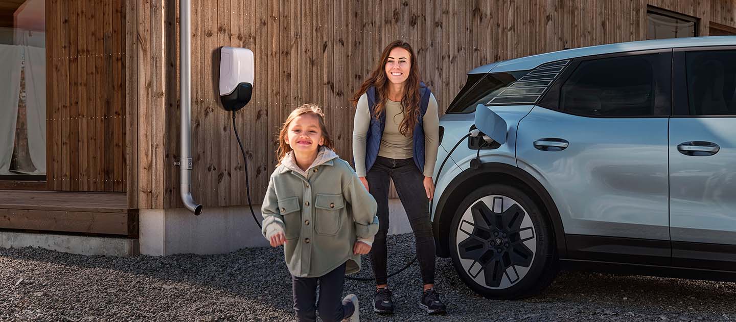 Rodzina bawiąca się podczas ładowania elektrycznego Forda Explorera w domu.