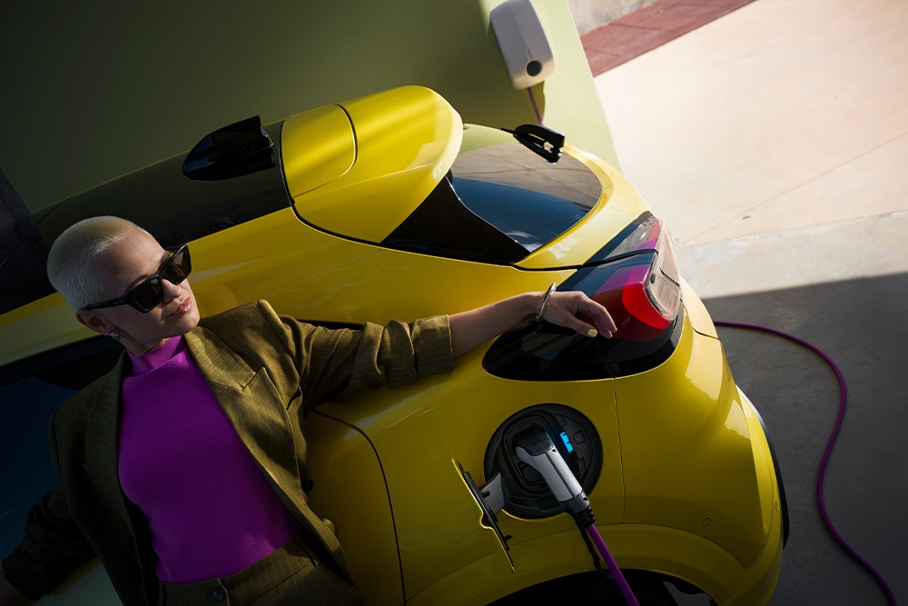 Osoba ładuje żółtego elektrycznego Forda Capri.