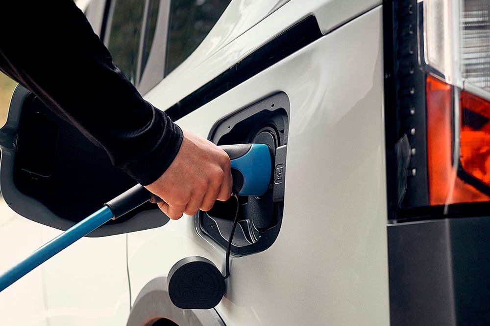 Osoba podłączająca elektrycznego Forda do kabla ładowania.