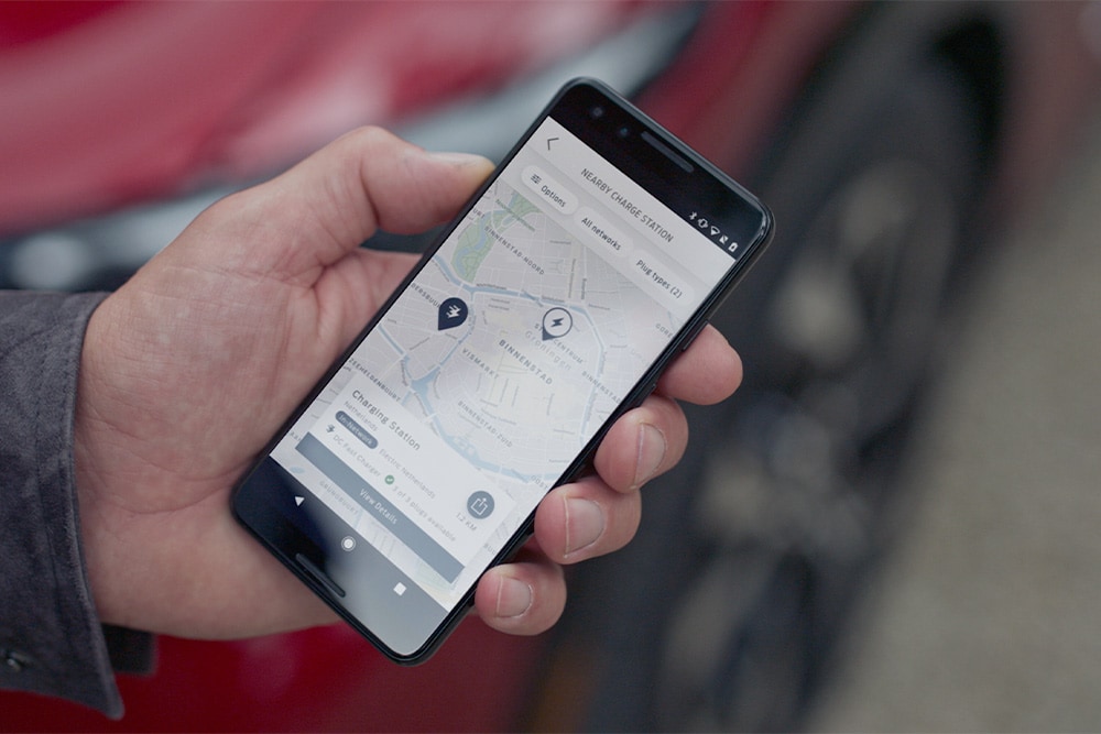 Smartfon wyświetlający aplikację FordPass™ z pobliskimi punktami ładowania.