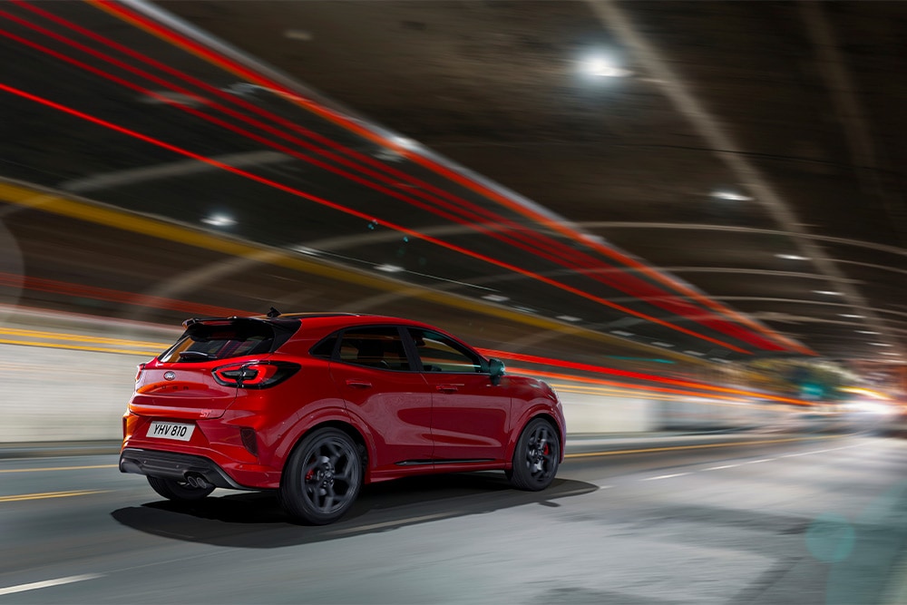Czerwony Ford Focus mild hybrid jadący przez tunel.
