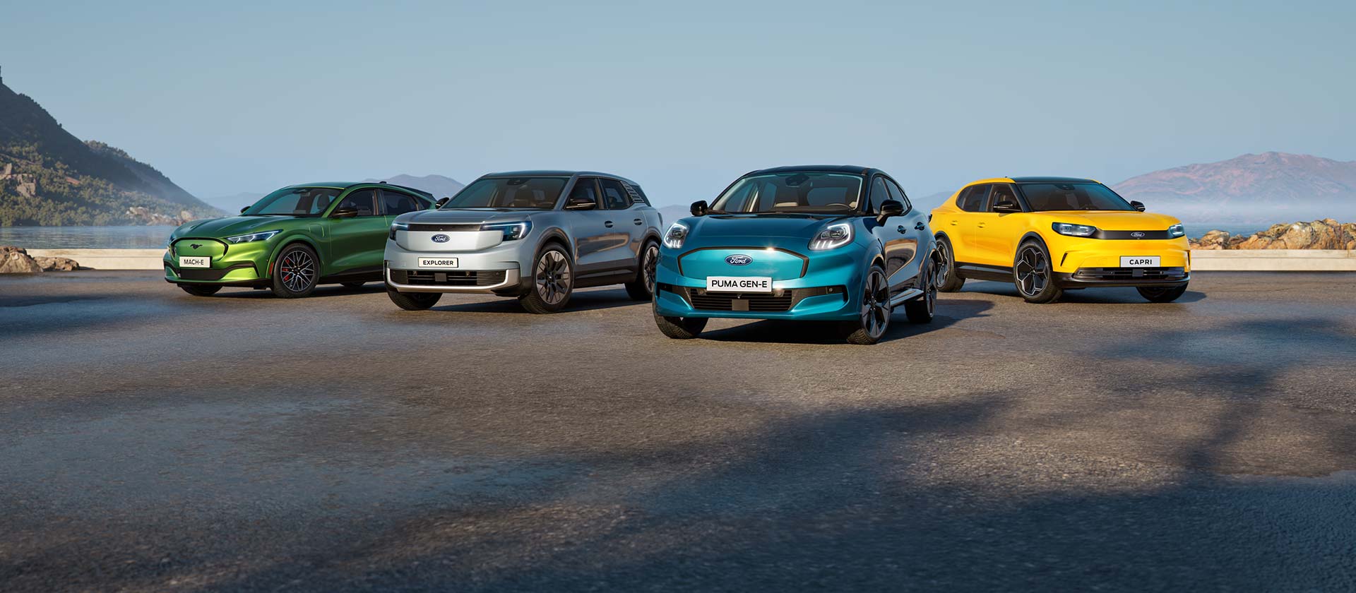 Samochody elektryczne Forda zaparkowane na tle surowego nadmorskiego krajobrazu.