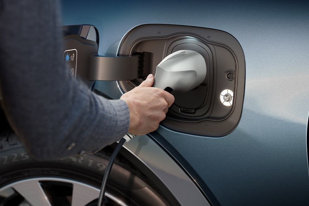 Zbliżenie na osobę ładującą elektryczny samochód Forda.