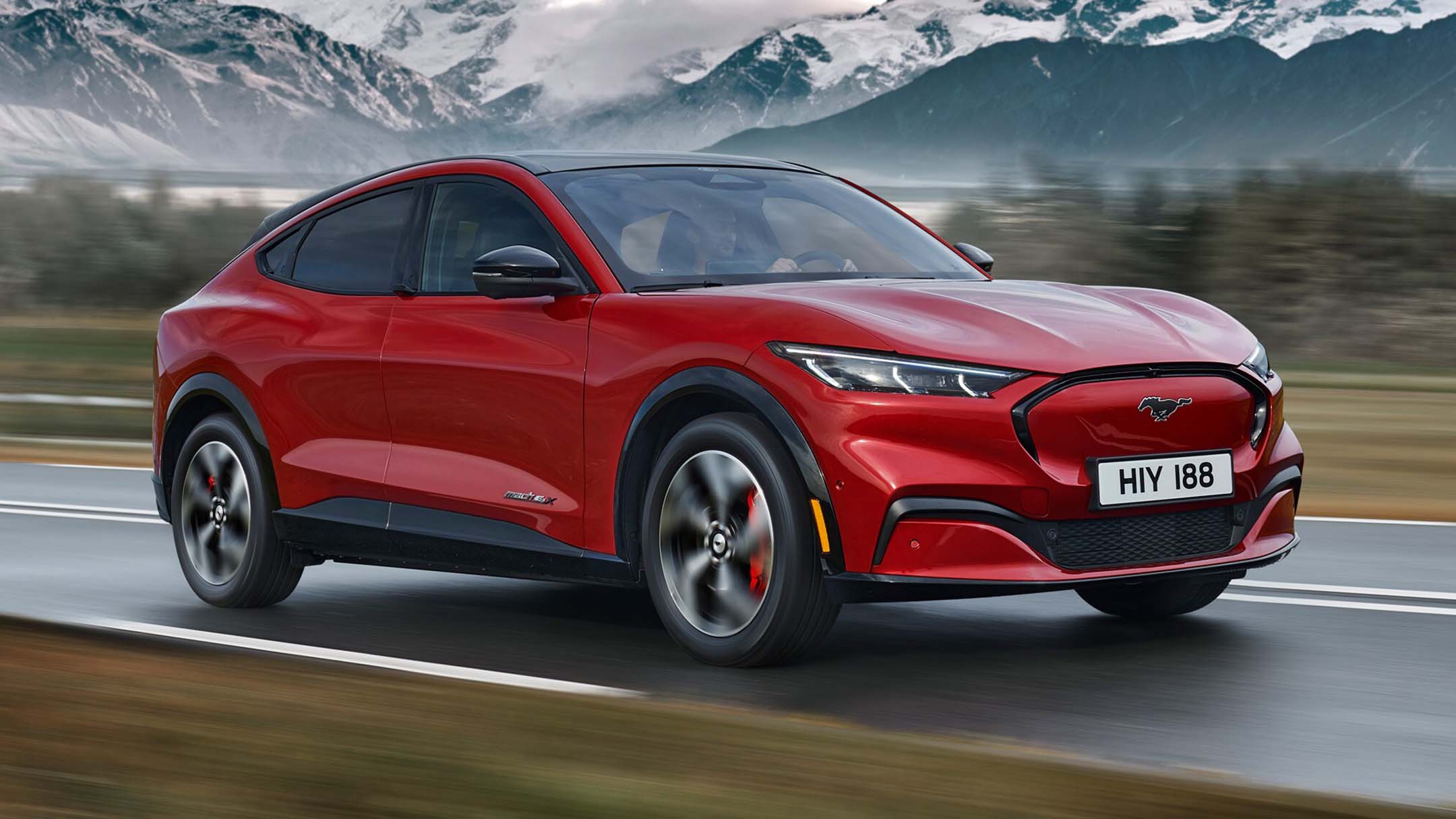 Red Mustang driving in the mountains