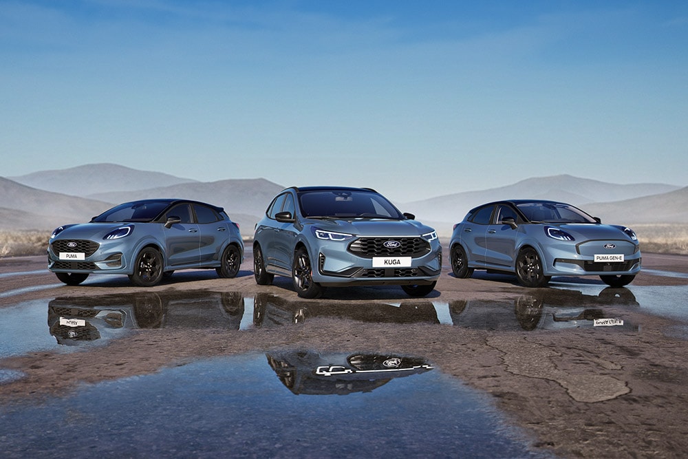 Ford Puma, Ford Kuga i Ford Puma Gen-E zaparkowane na drodze na tle gór.