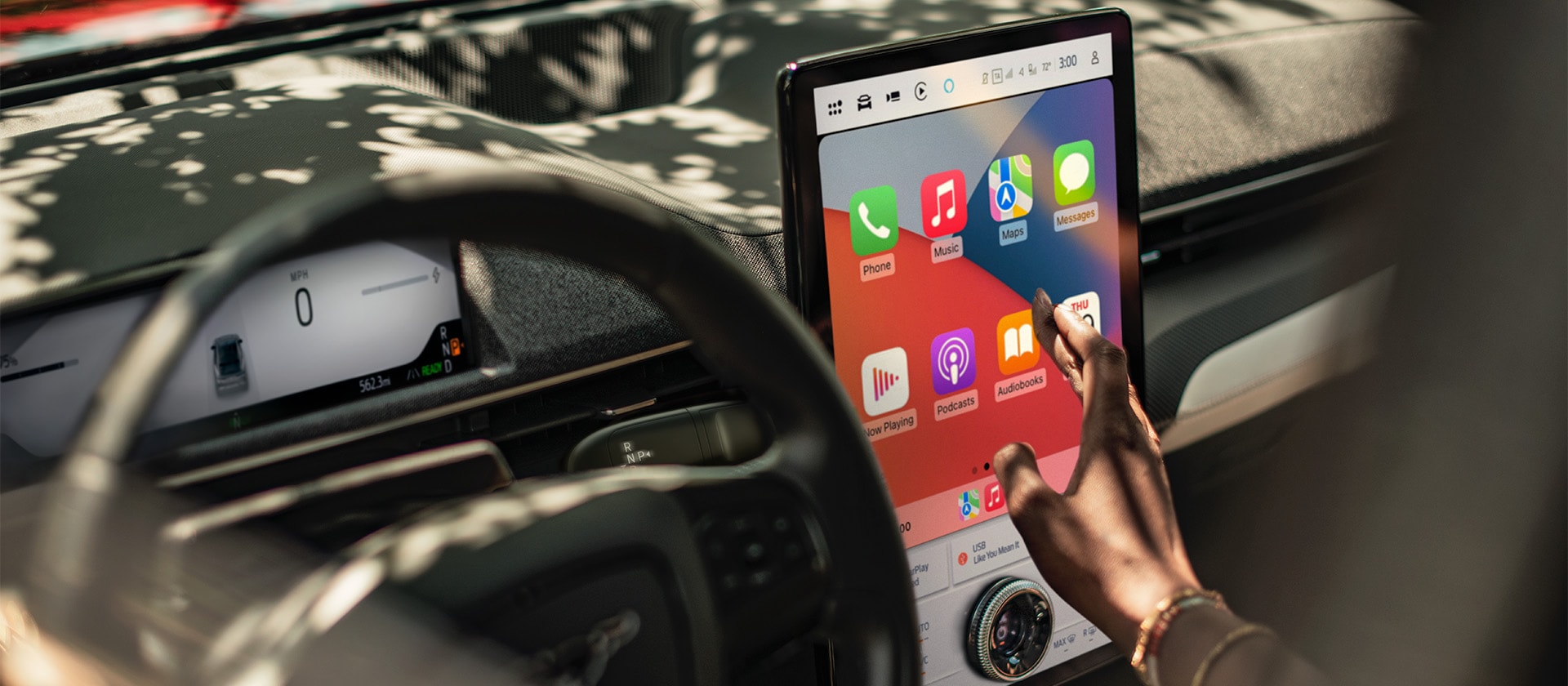 Kierowca Forda Mustanga Mach-E korzystający z 15,5" dużego ekranu dotykowego SYNC 4 z uruchomioną funkcją Apple CarPlay. 