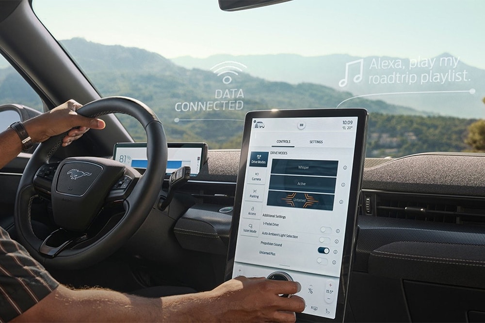 A person driving a Ford mustang mach-e whilst using sync 4 screen