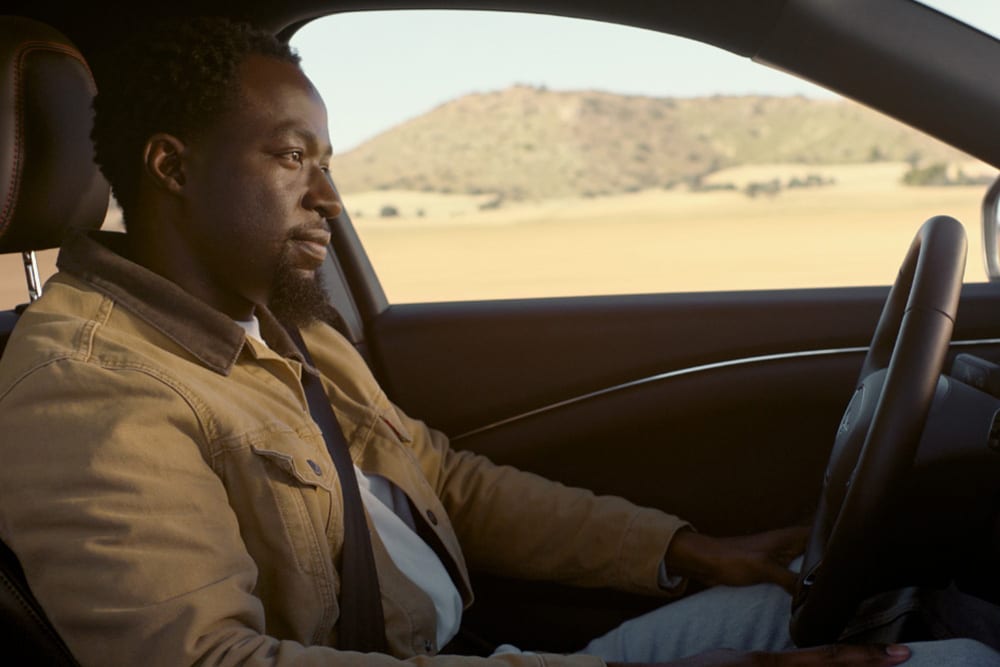 A man driving a Ford Mustang Mach-E using BlueCruise hands off, eyes on technology.