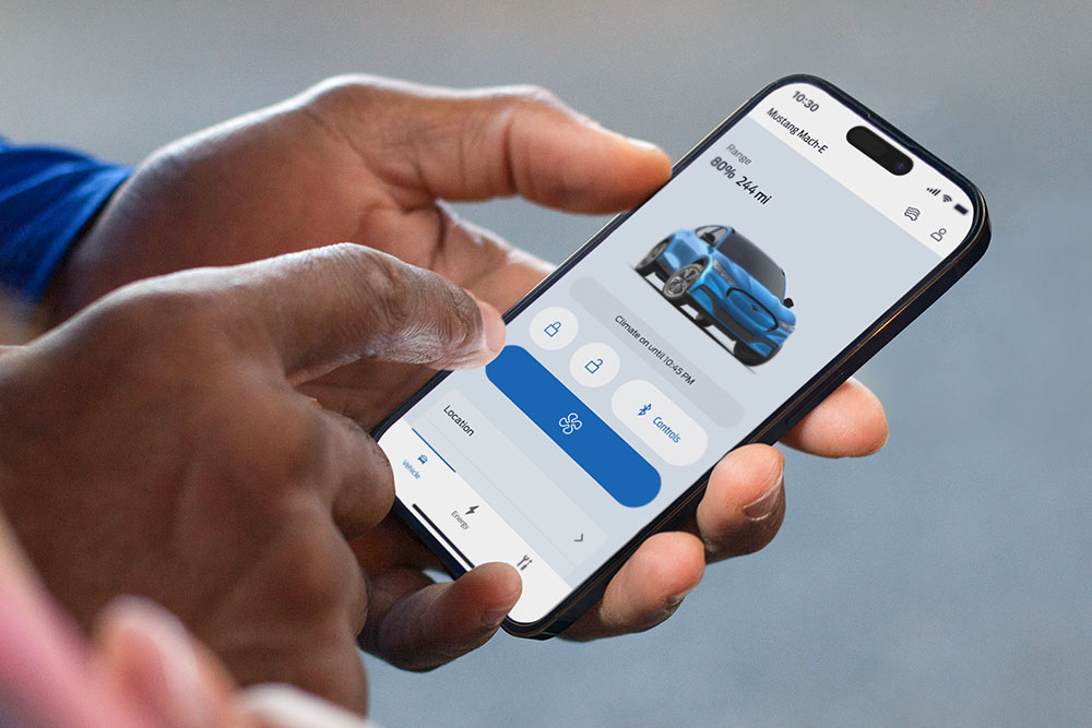 Zbliżenie na iPhone'a z uruchomioną aplikacją FordPass z grafiką Forda Mustanga Mach-E i przyciskami w aplikacji.