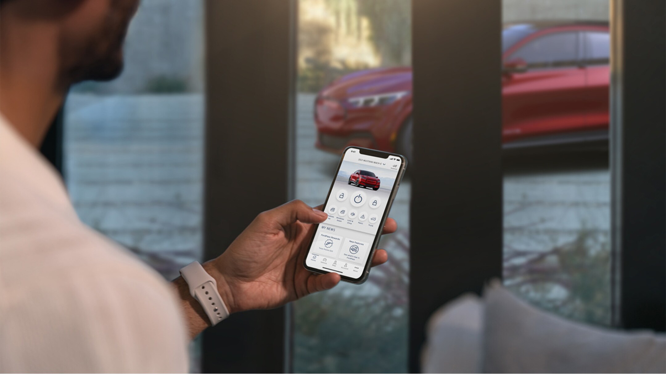 A man checking the settings of his All-New Ford Mustang Mach-E using the Remote Vehicle Control features in the FordPass app