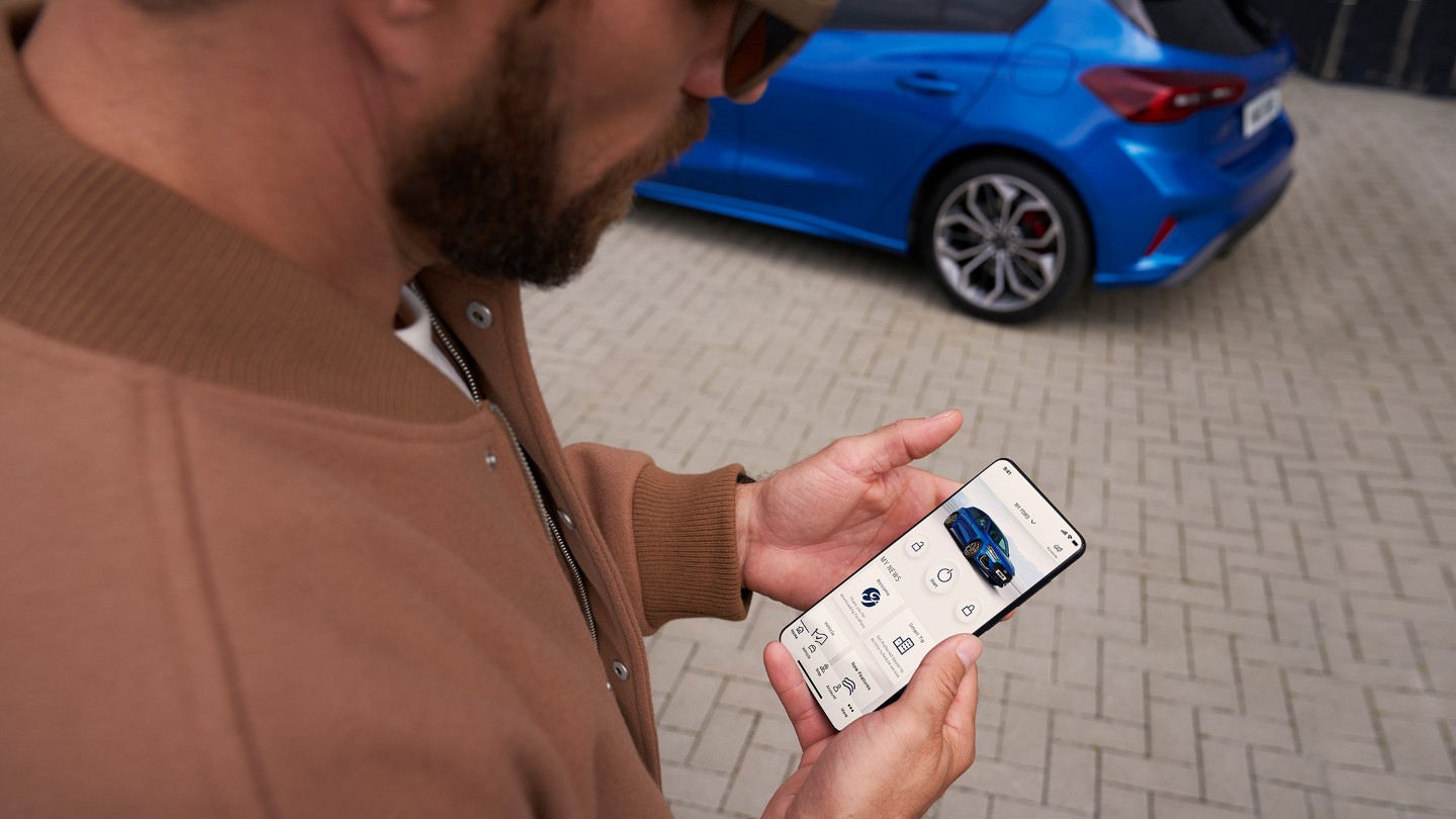 Man looking at smartphone with FordPass App open