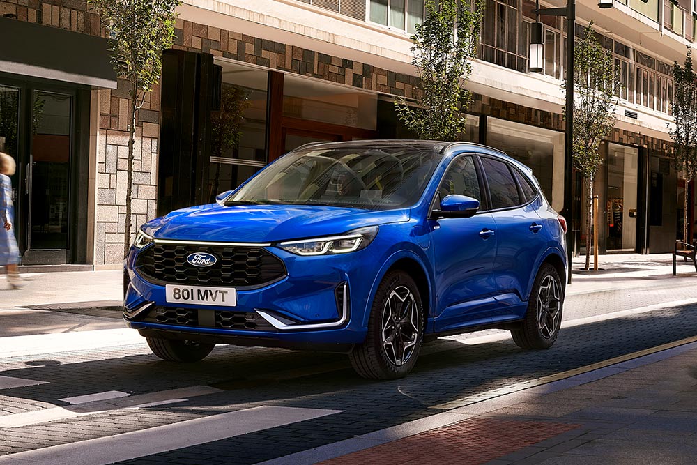 Ford Kuga ST Line w kolorze Desert Island Blue zaparkowany w dzielnicy mieszkalnej. 