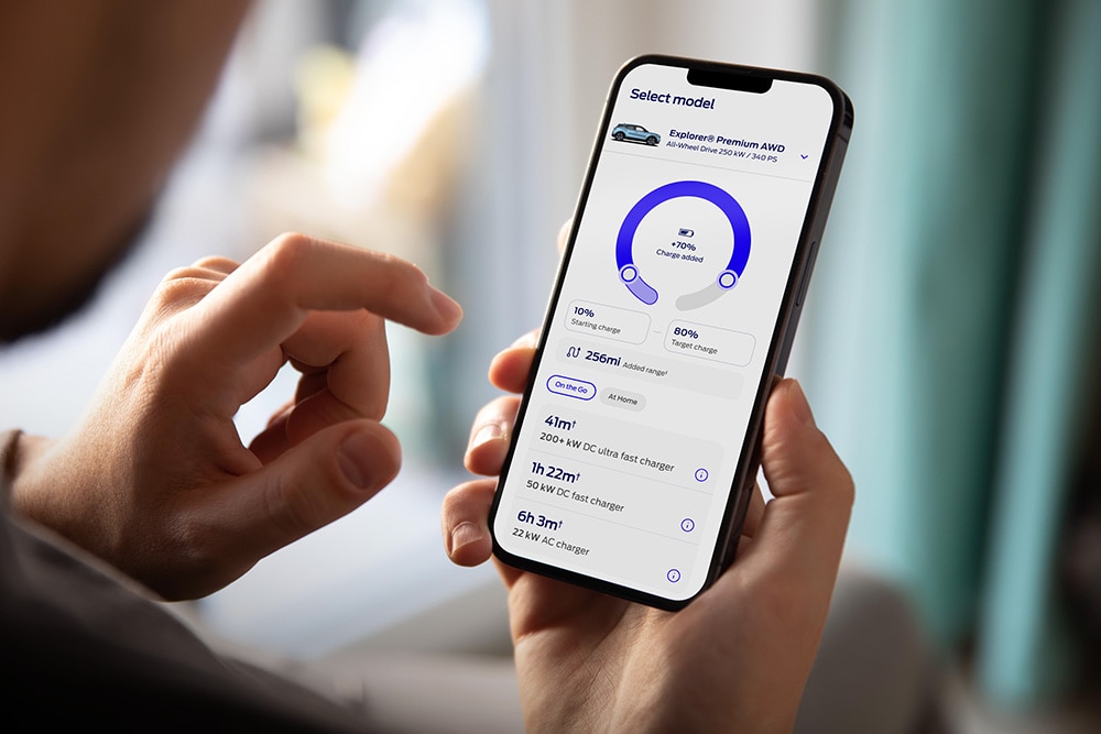 Zbliżenie na smartfon wyświetlający kalkulator zasięgu dla elektrycznych Fordów i narzędzie do obliczania czasu ładowania.