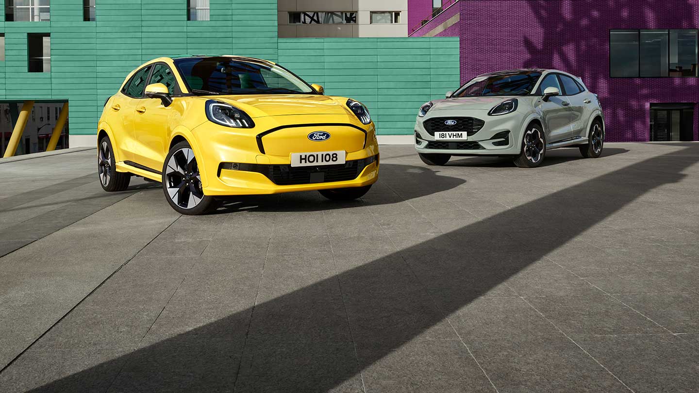 Żółty elektryczny Ford Puma Gen-E® zaparkowany obok szarego Forda Puma® z benzynowym silnikiem EcoBoost®. 
