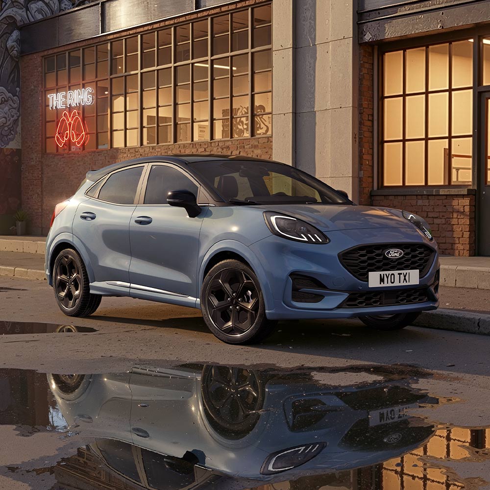 Ford Puma w kolorze Vapour Blue w limitowanej wersji zaparkowany przy słabo oświetlonej miejskiej ulicy w nocy.