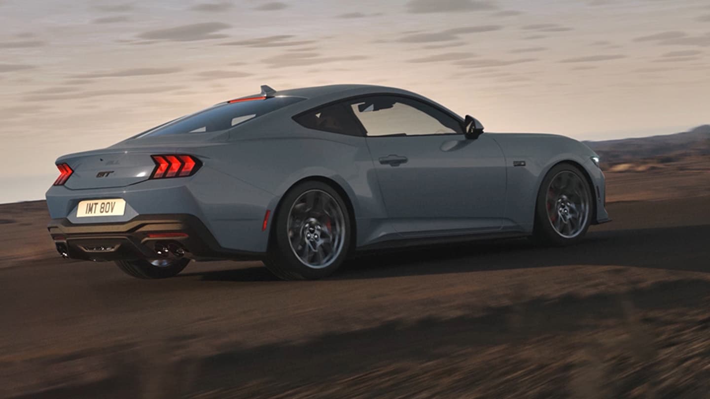 Niebieski Ford Mustang jadąy drogą wśród wzgórz