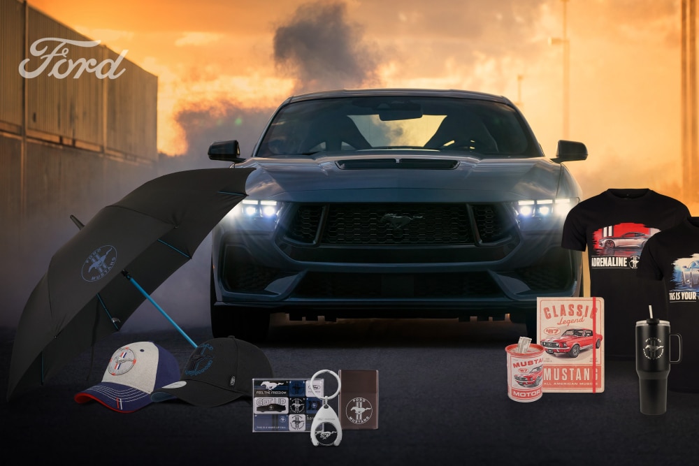 Kolekcja Ford Mustang z szarym Mustangiem w tle oraz gadżetami Mustang – parasolką, czapkami, kubkami i koszulkami.