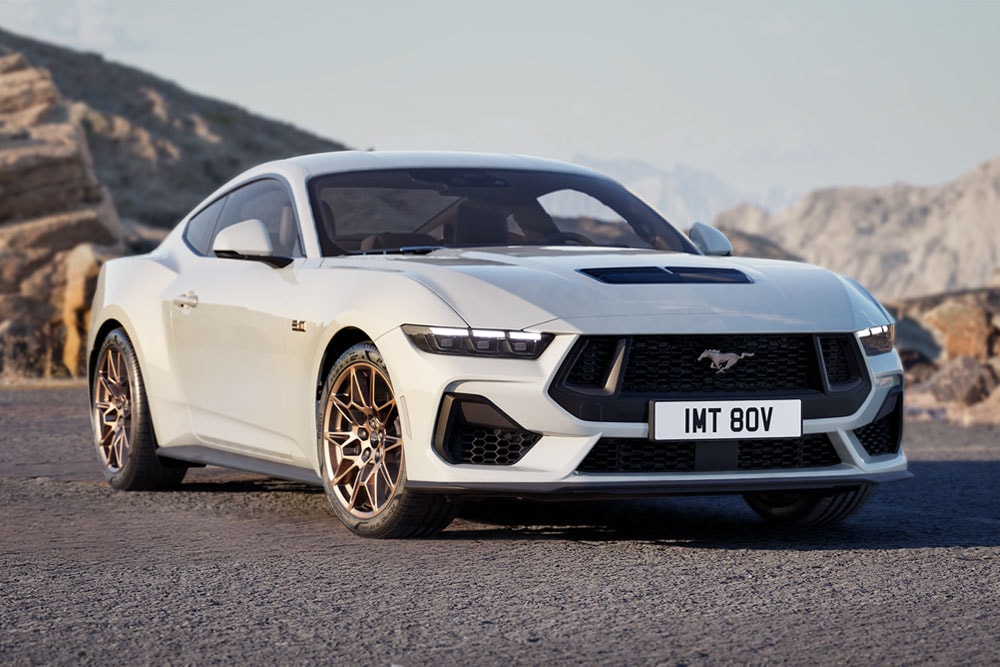 Ford Mustang GT Fastback z pakietem Bronze Pack w kolorze Oxford White zaparkowany na górskiej drodze