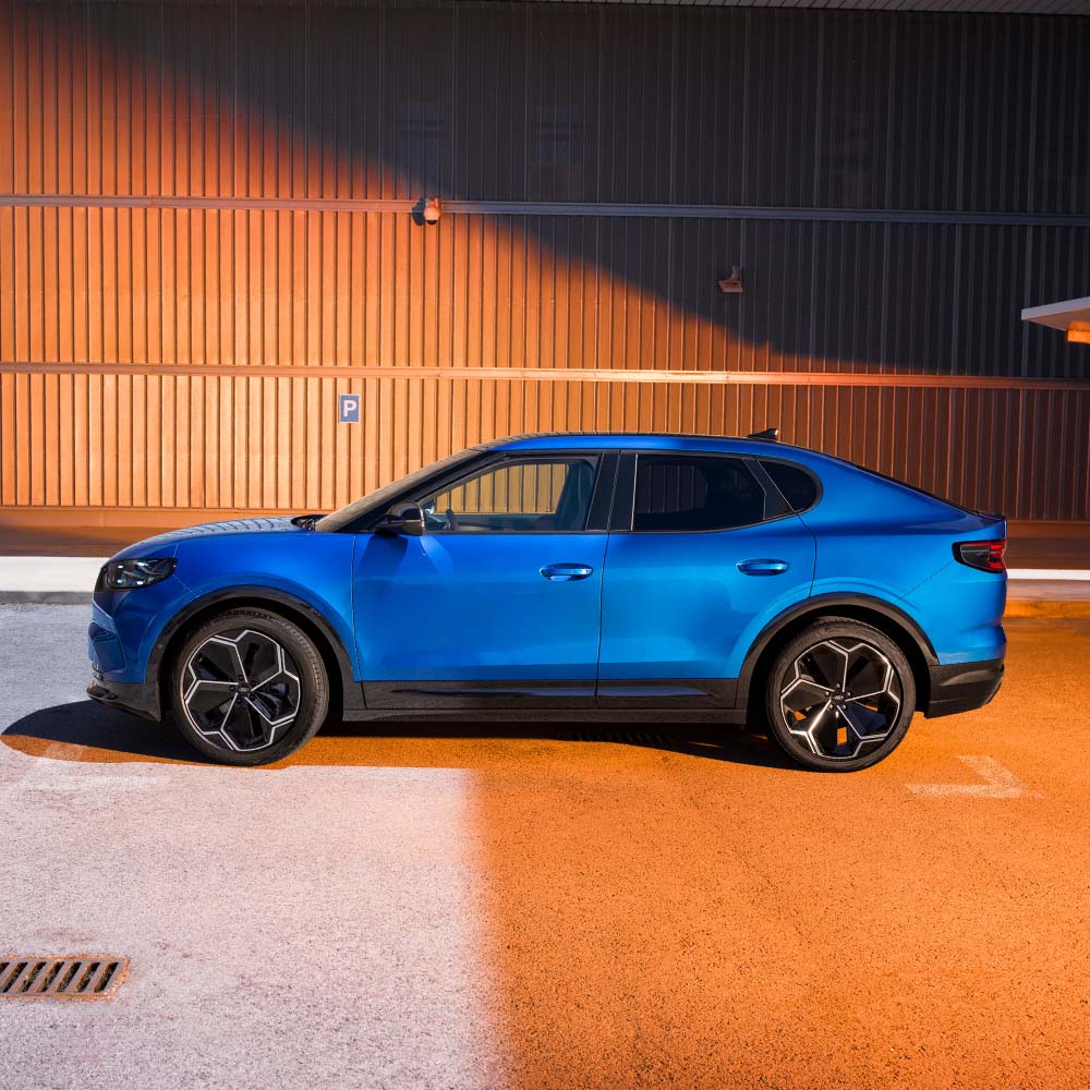 Widok z boku na niebieskiego Forda Capri.  w prawym górnym rogu pokazana jest 5-gwiazdkowa ocena bezpieczeństwa 2024 Euro NCAP.