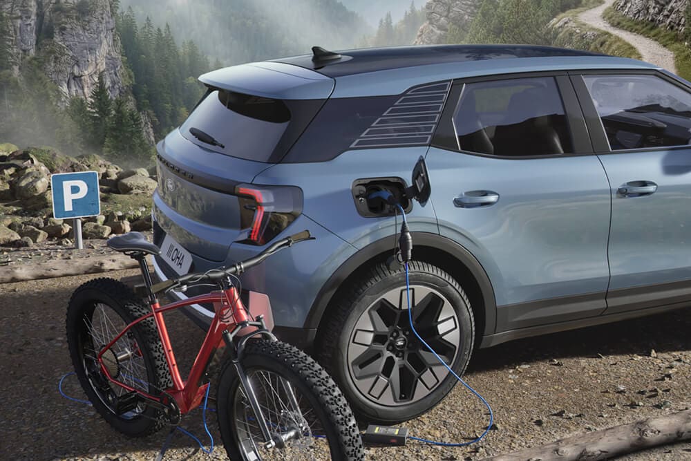 Ford Explorer® ładujący elektryczny rower na tle górskiego krajobrazu.