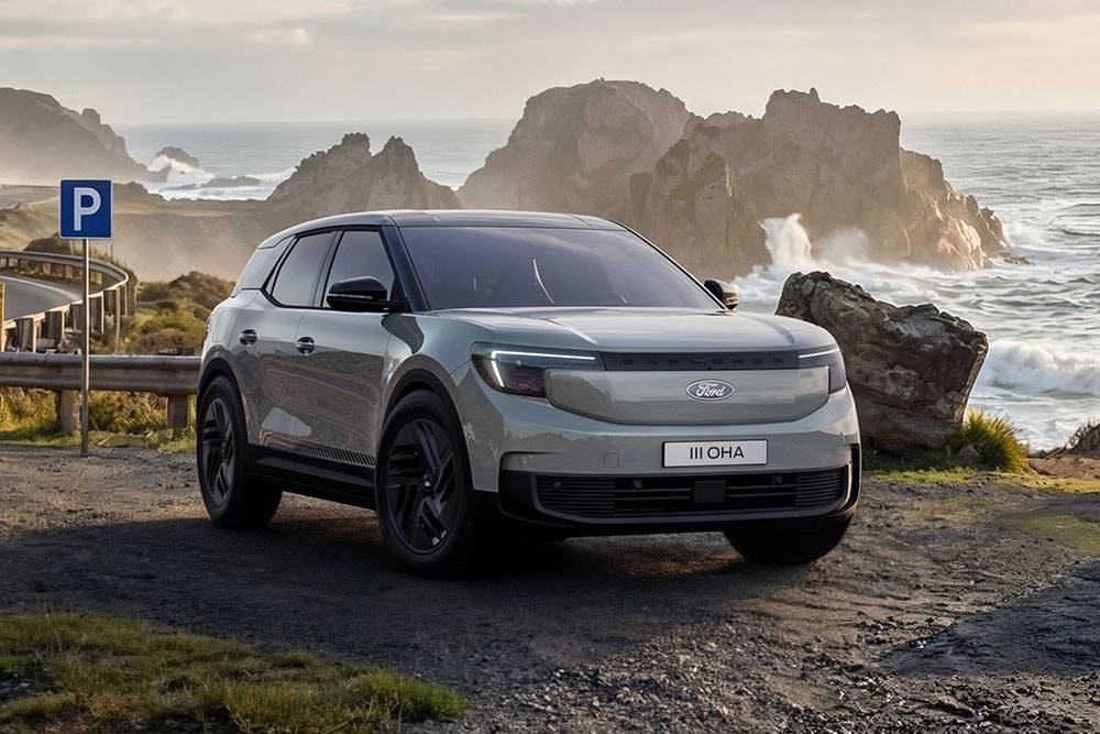 Srebrny Ford Explorer® Collection zaparkowany na drodze przy skalistej linii brzegowej.