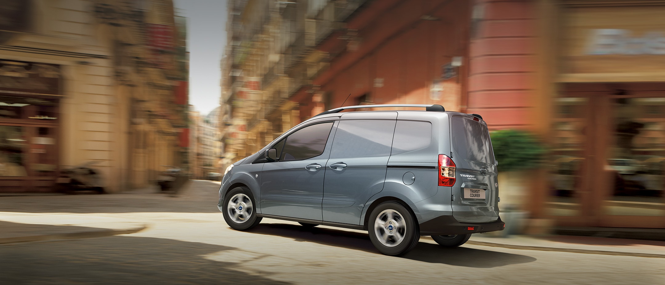 Silver Ford Transit Courier in city lanes