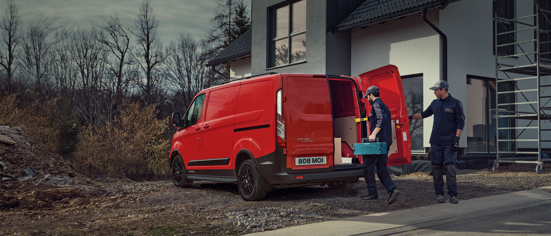 Transit Custom parked near building with two men loading up