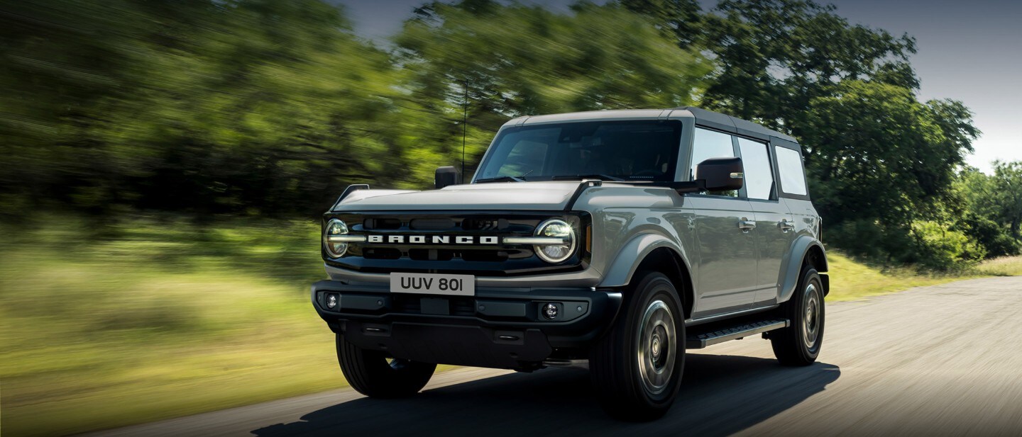 Ford Bronco driving along country road Ford Bronco driving along country road