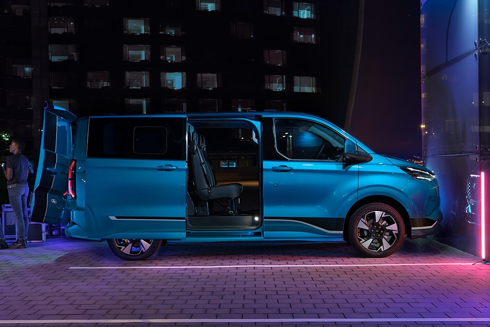 Niebieski elektryczny van Ford E-Transit Custom z podwójną kabiną z otwartymi drzwiami.