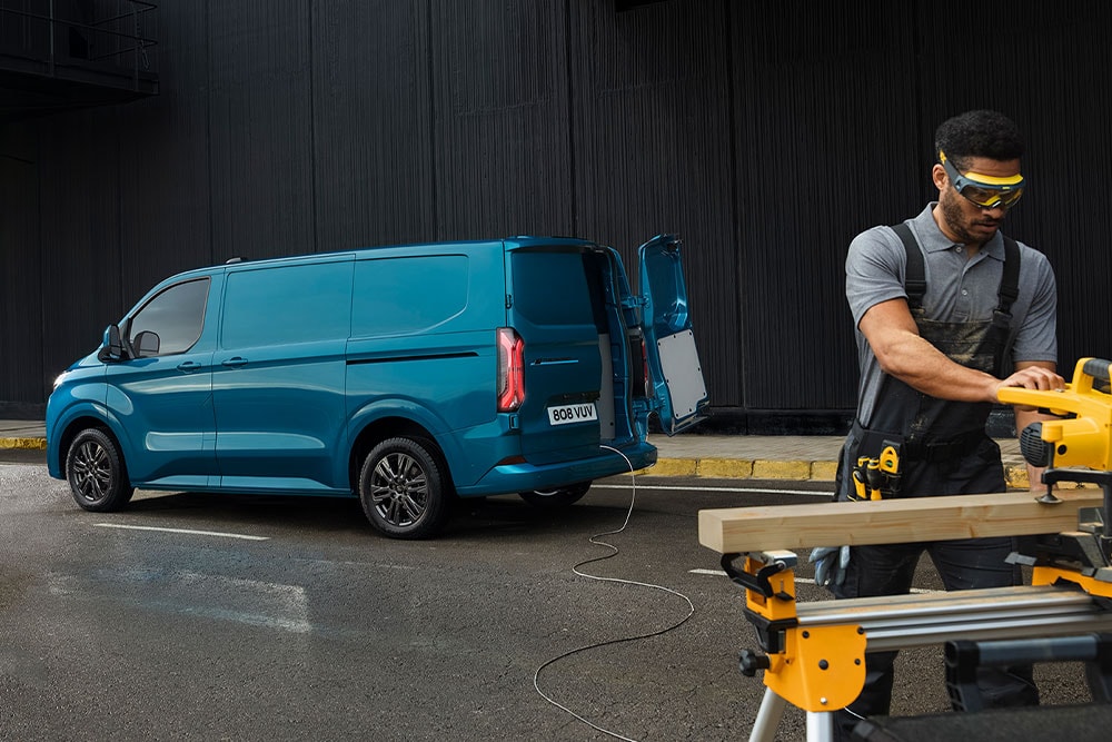 Osoba korzystająca z elektronarzędzi podłączonych do systemu Pro Power Onboard w vanie Ford Transit Custom.