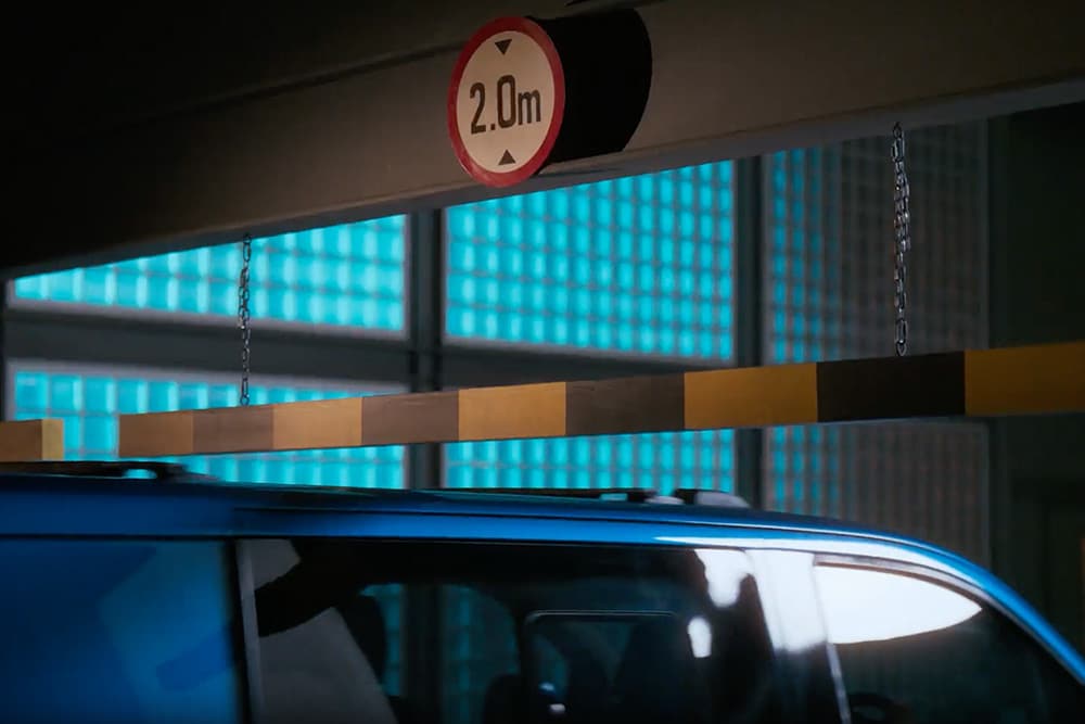 Niebieski Ford Transit Custom Van wjeżdżający na parking.