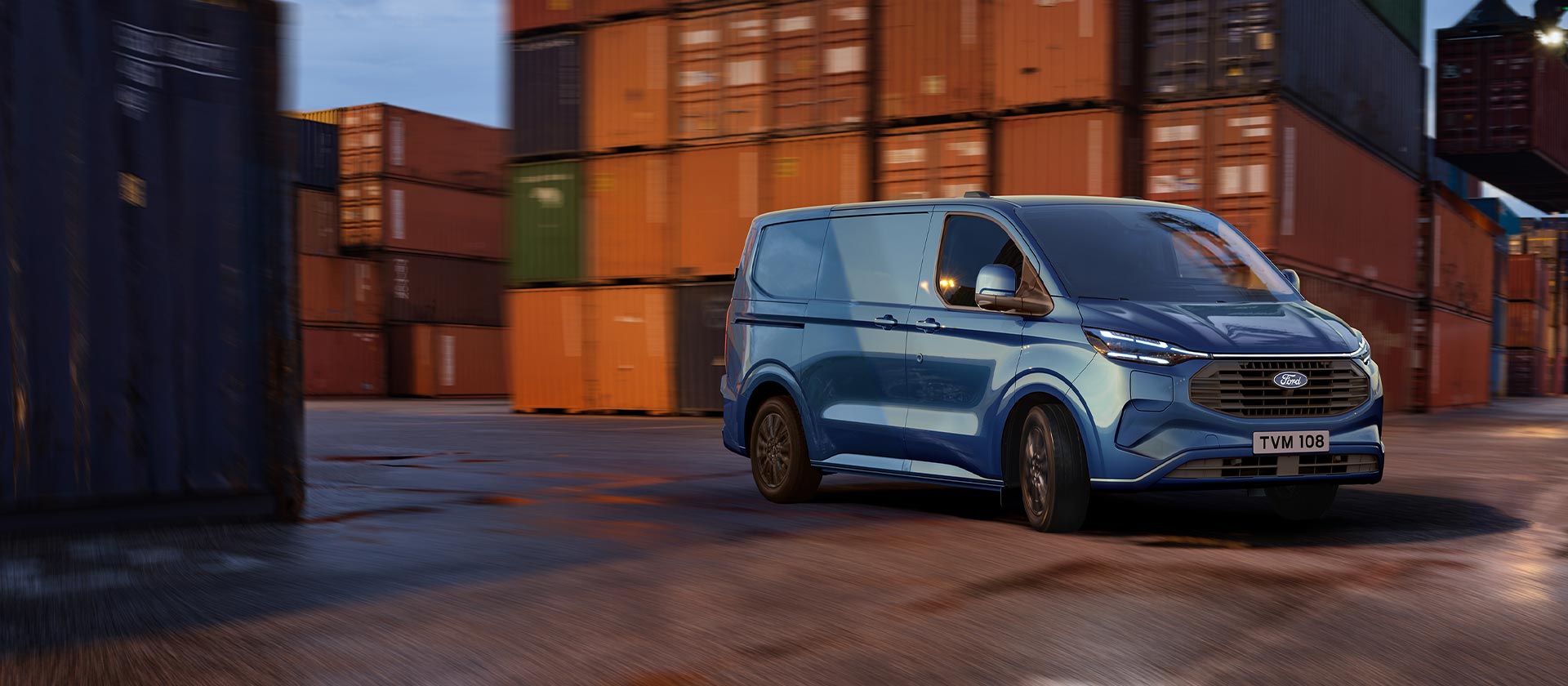 Niebieski van Ford Transit Custom Plug-in Hybrid przejeżdża przez teren stoczni.