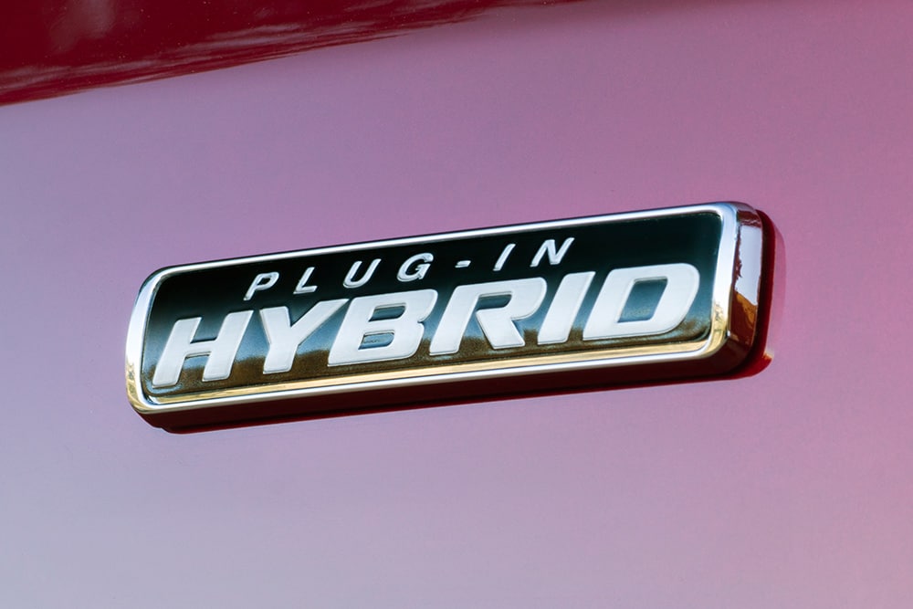 Plakietka „Plug-in Hybrid” na czerwonym Fordzie Transit Custom.