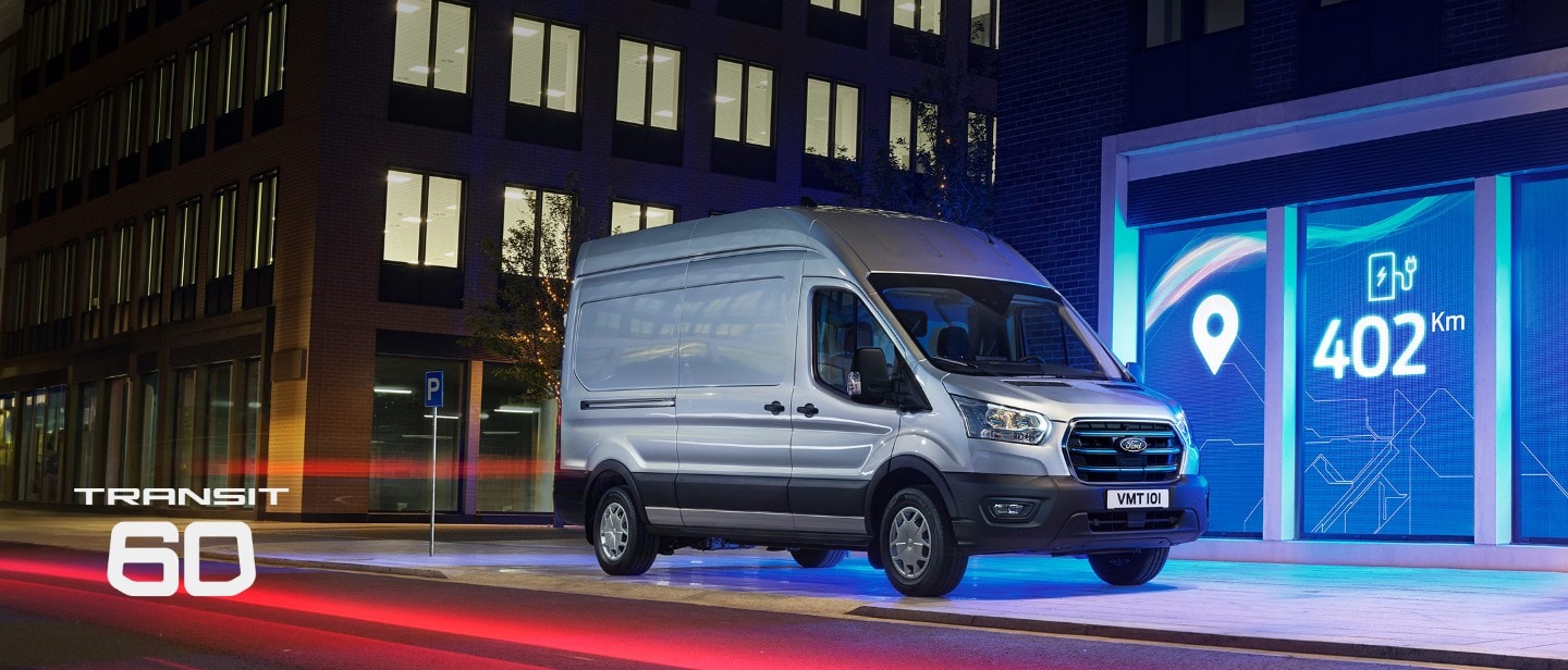 New E-Transit side view with the backdrop of city in night with blue electric lights