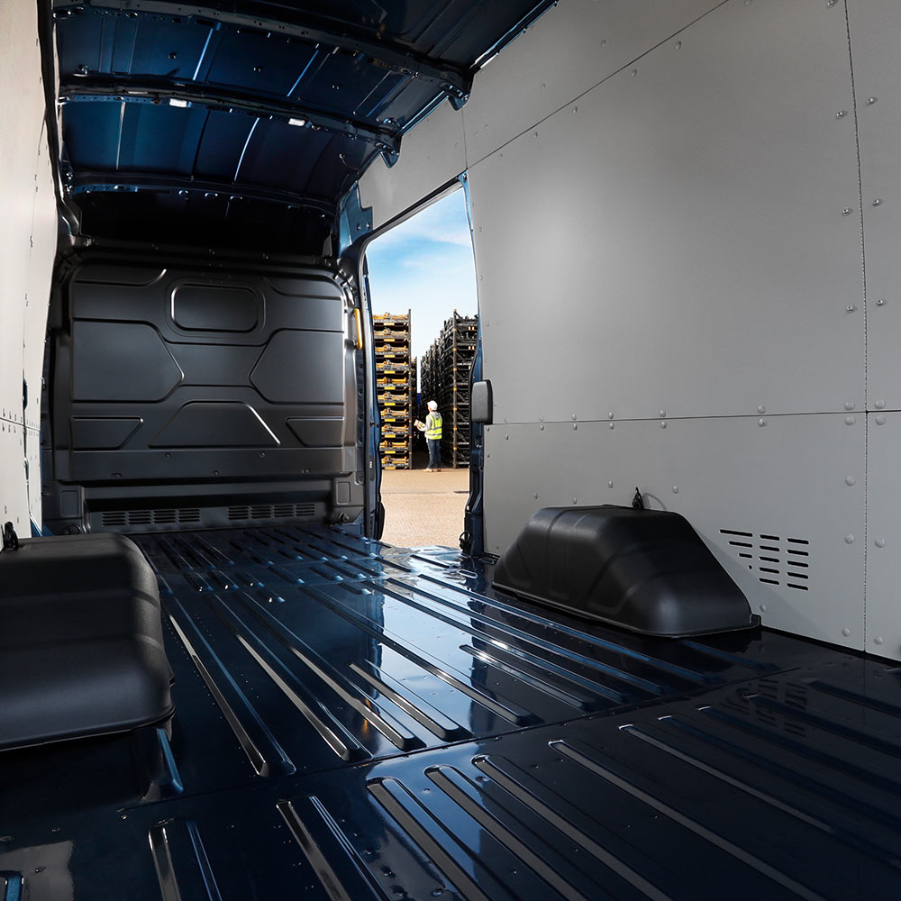 Wnętrze elektrycznego vana Ford E-Transit z pustą przestrzenią ładunkową.