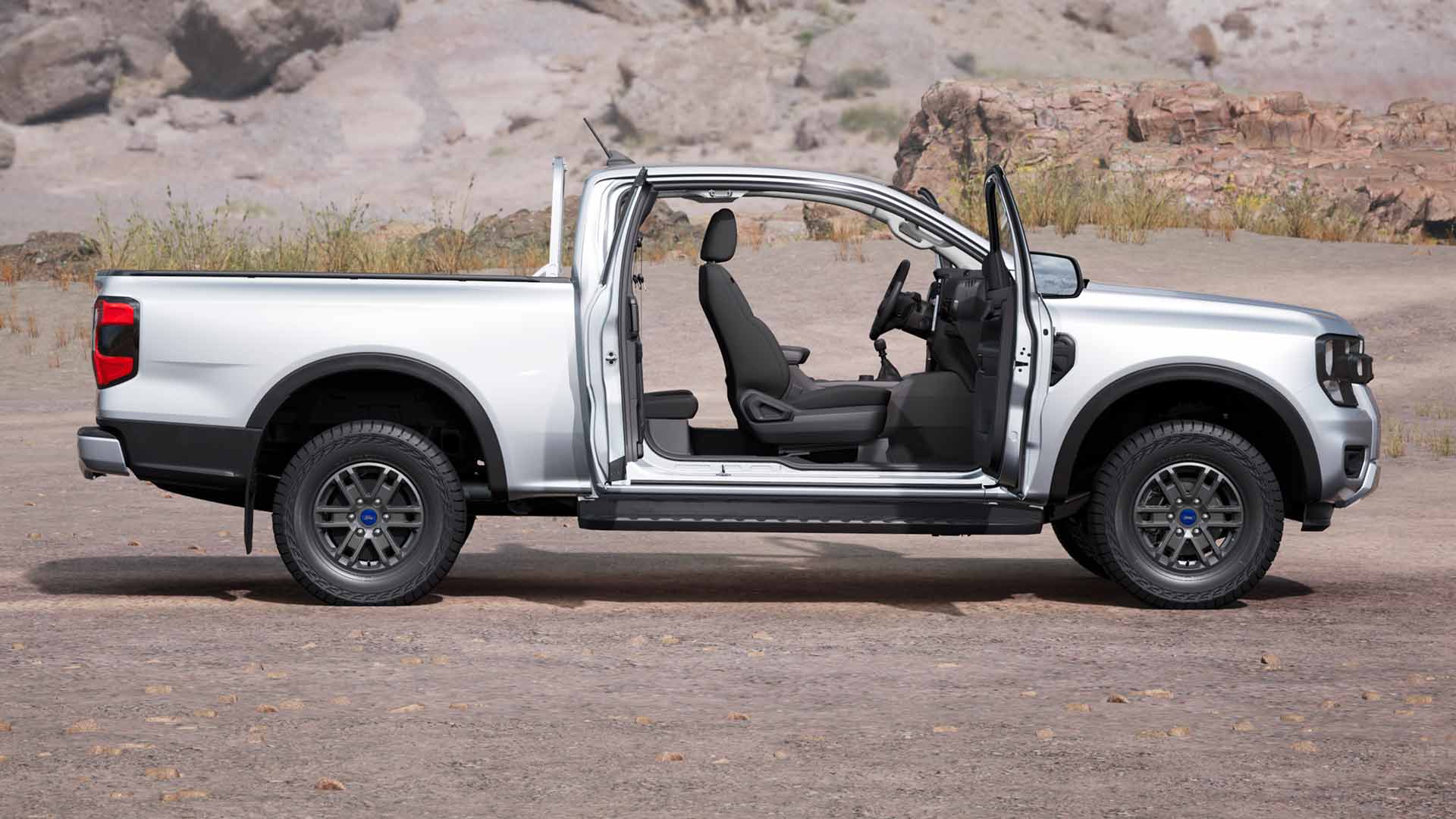 Srebrny Ford Ranger XLT z przedłużoną kabiną z otwartymi drzwiami, zaparkowany w terenie.