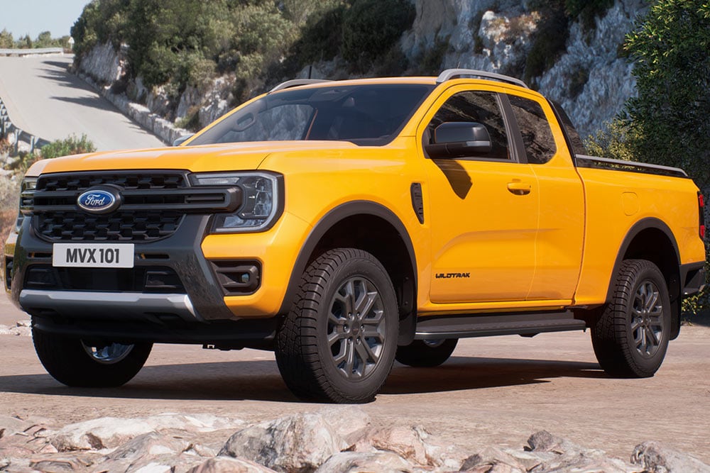 Yellow Ford Ranger Wildtrak Super Cab parked on a sandy surface, viewed from the front.