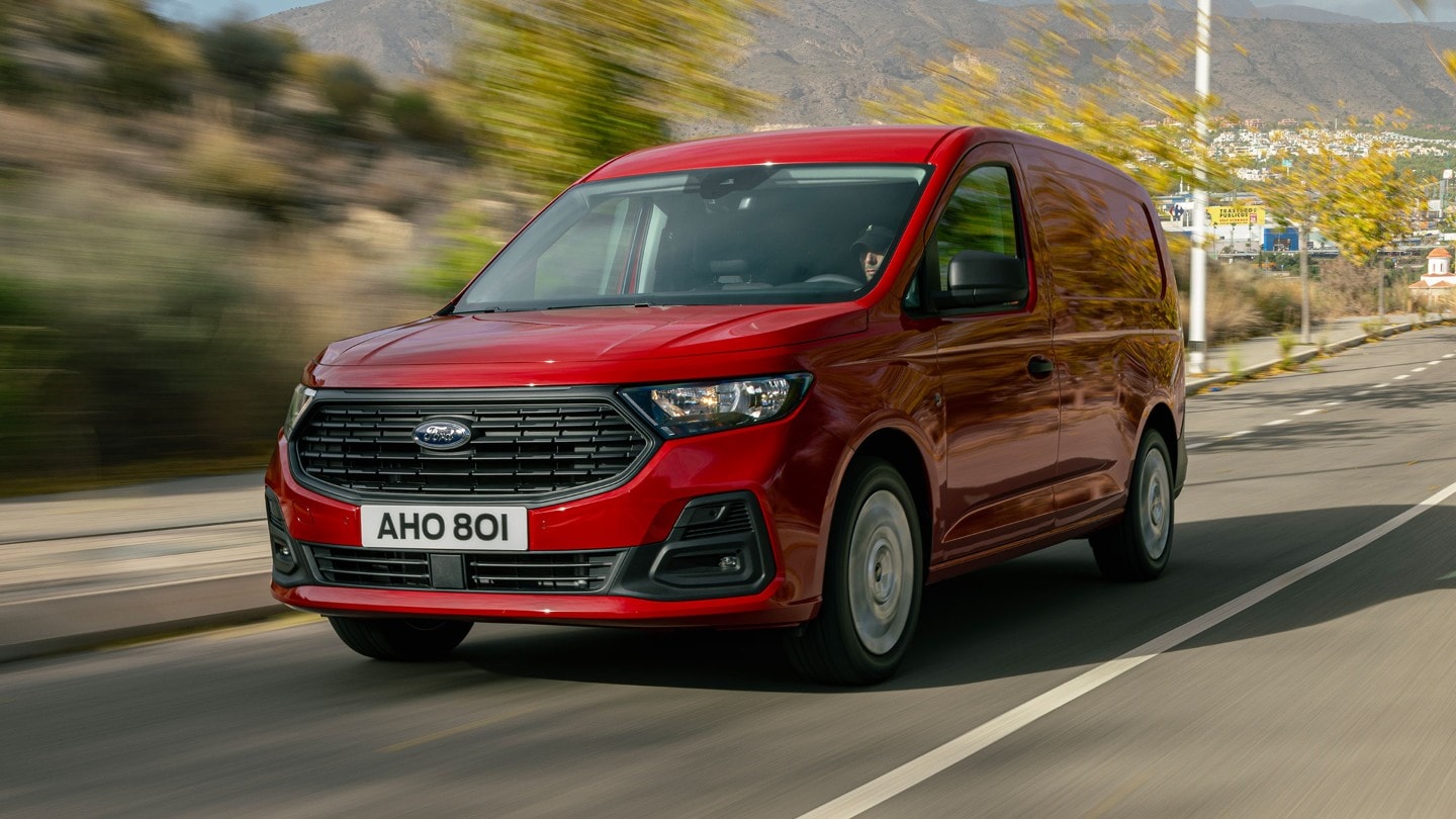 Red Ford Transit Connect driving on the road