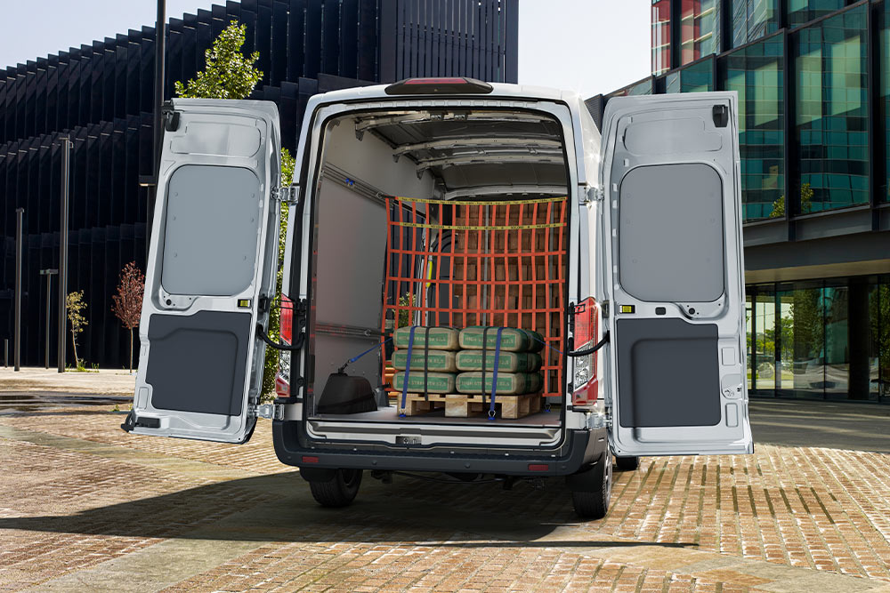 Ford Transit Van brygadowy z otwartymi tylnymi drzwiami i ładunkiem wewnątrz.