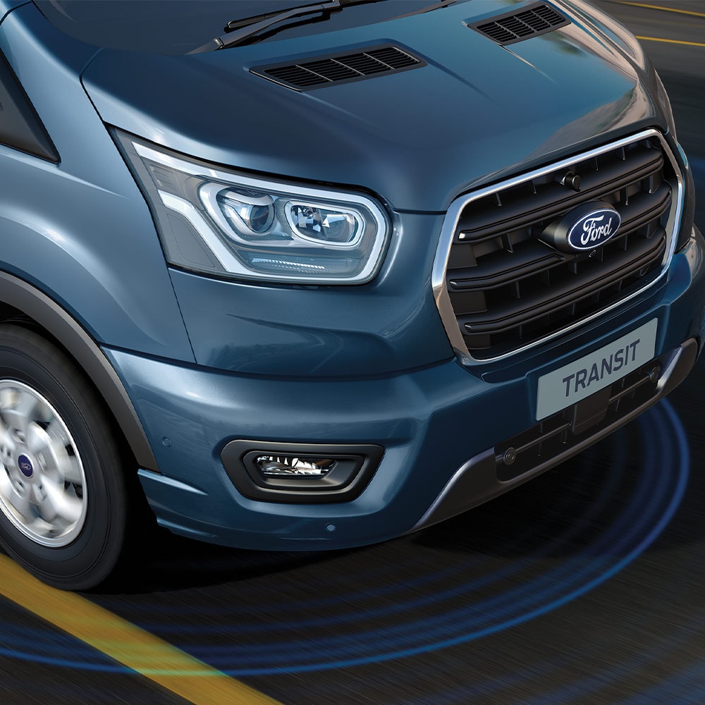 Niebieski Ford Transit Van z niebieskimi liniami na drodze wskazującymi na korzystanie z zaawansowanych systemów wspomagających kierowcę.