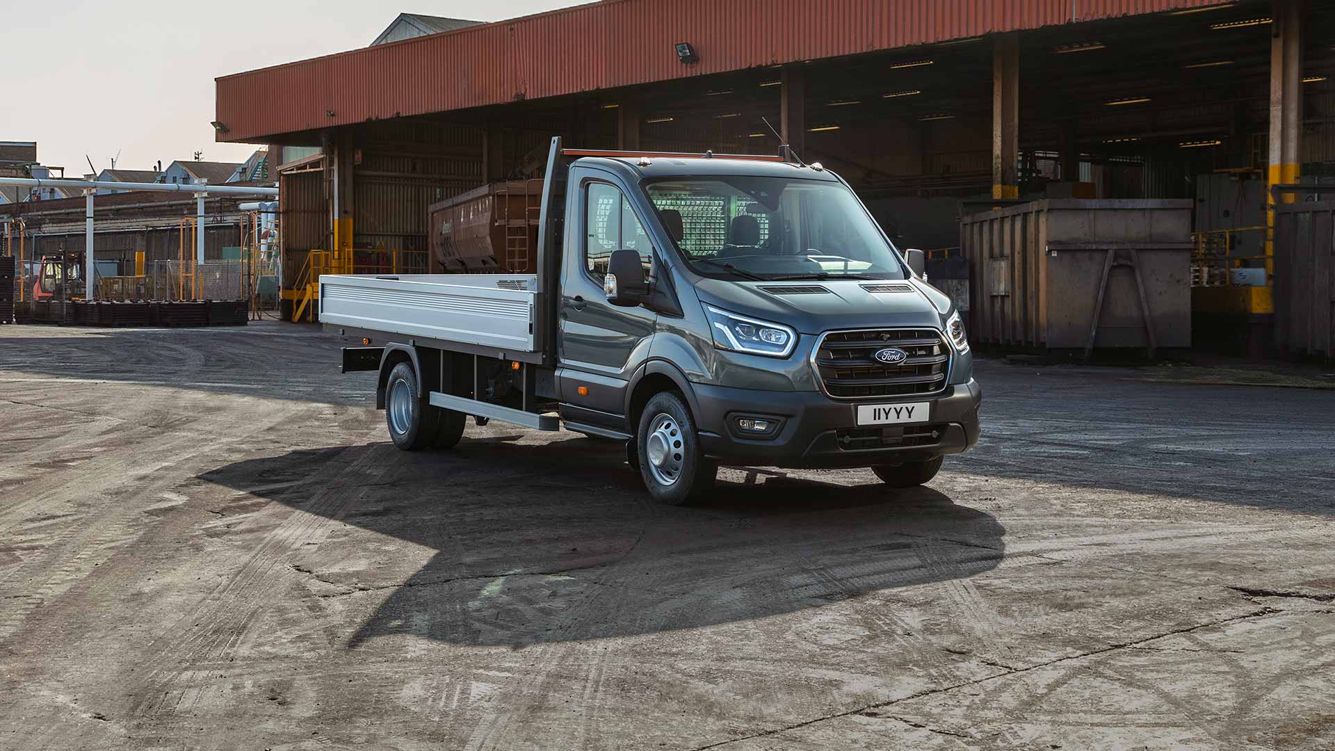 Ford Transit typu podwozie z kabiną zaparkowany na terenie przemysłowym.