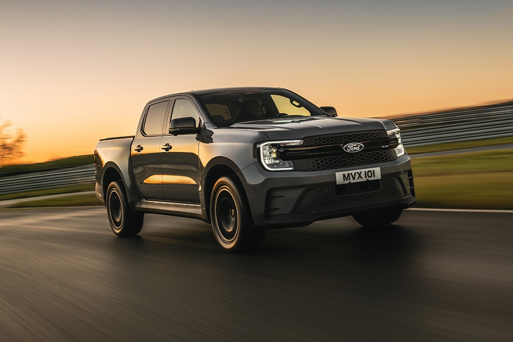 Ciemnoszary Ford Ranger Platinum jedzie po torze o zachodzie słońca.