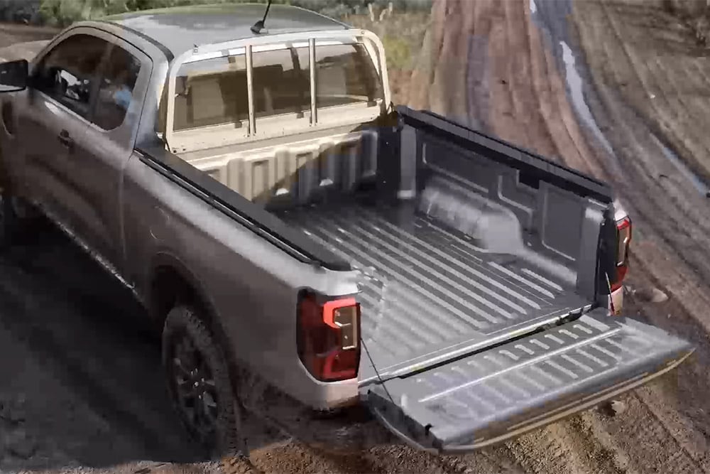 Srebrny Ford Ranger XLT z przedłużoną kabiną zaparkowany na błotnistym podłożu z otwartą tylną klapą – widok z góry.