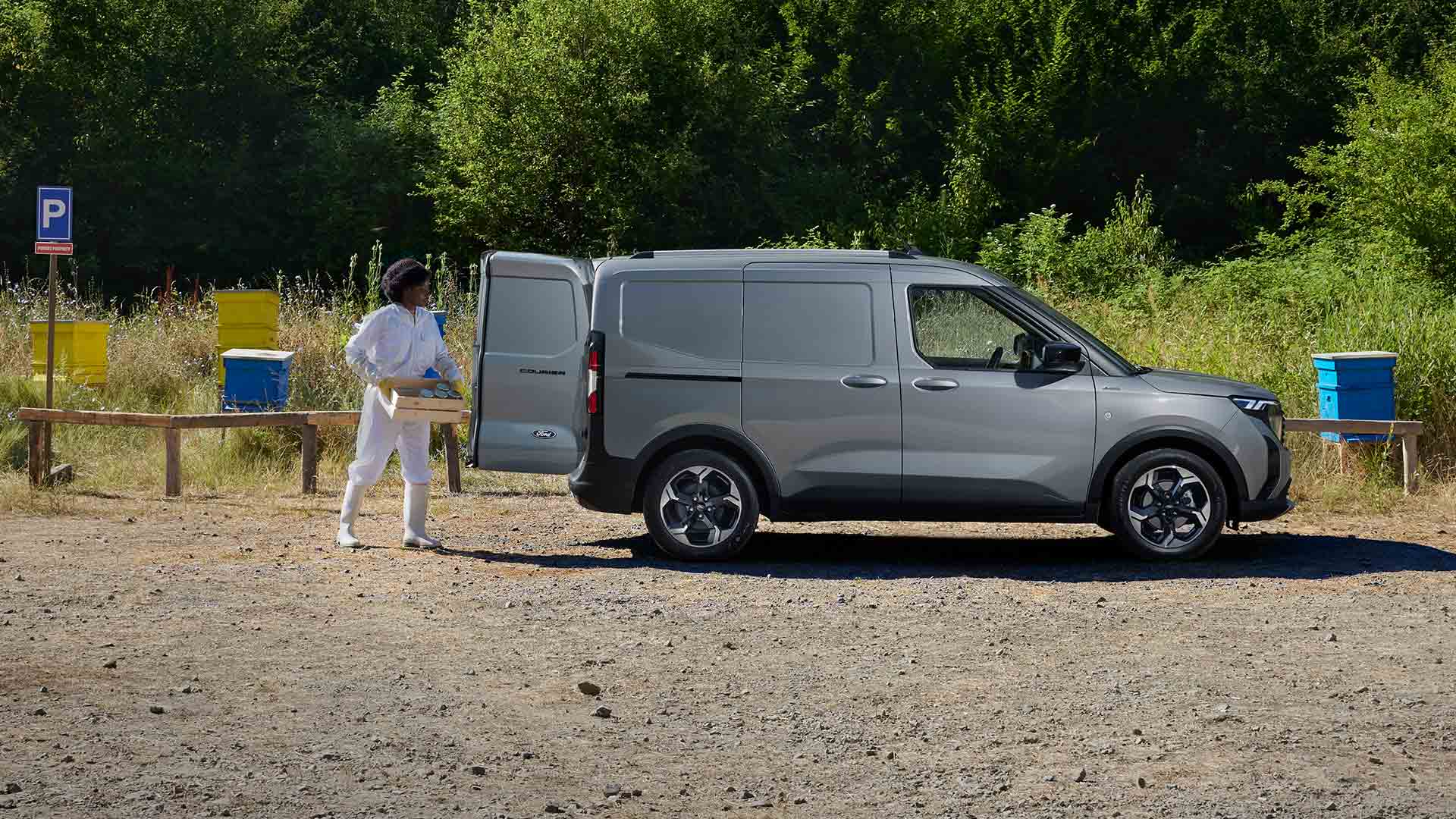 Pszczelarz ładujący miód do Forda Transit Courier