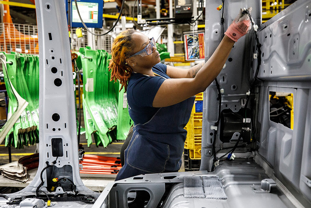 Mechanik Forda pracujący przy vanie w garażu.