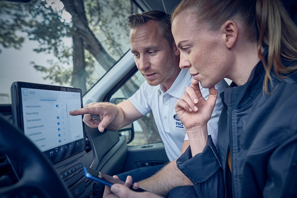 Kilka elektrycznych pojazdów floty Forda zaparkowanych przed magazynem.