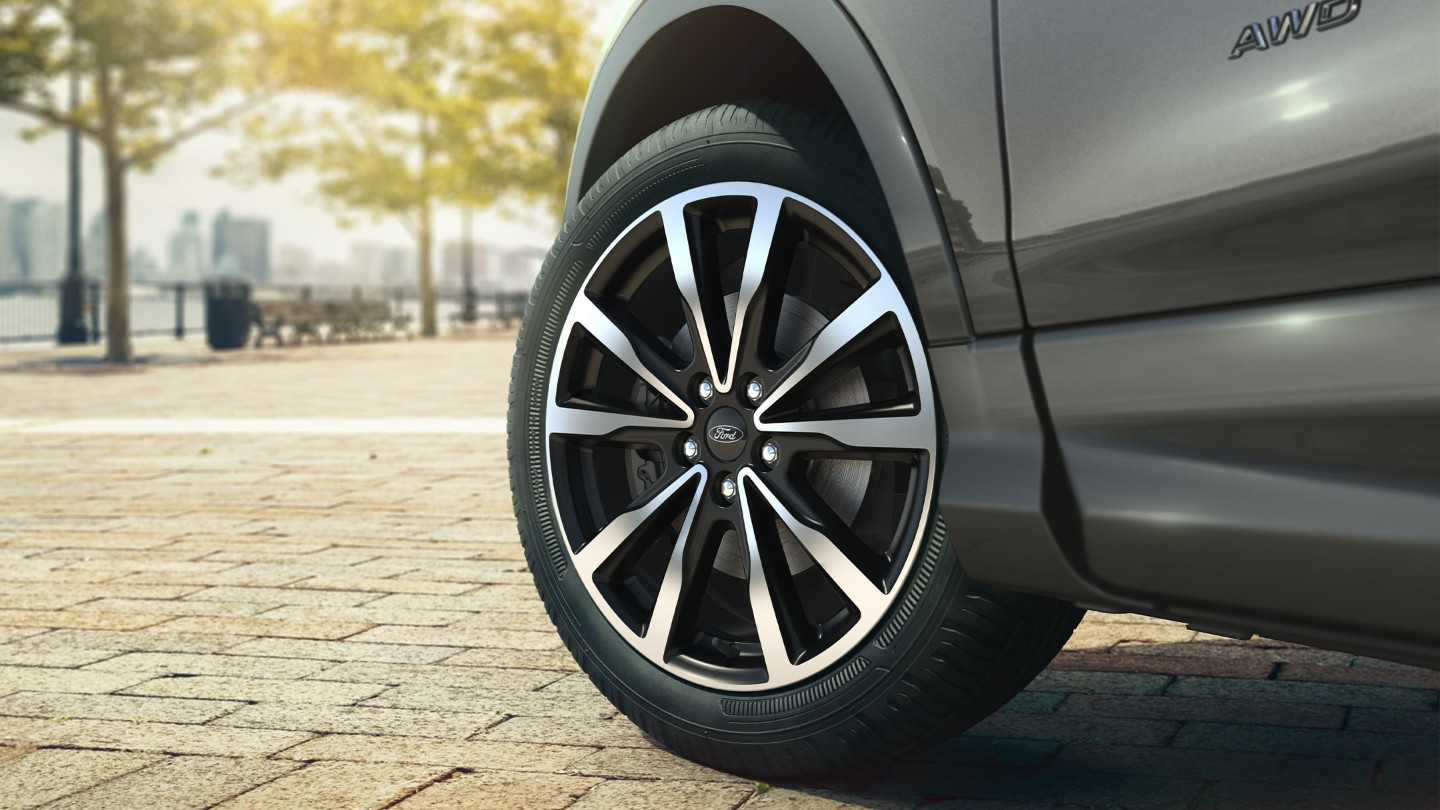 Ford wheel with a city view behind